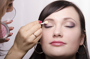 Image showing Makeup artist colors upper eyelids model