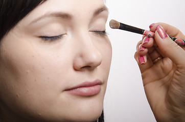 Image showing Makeup artist colors upper eyelids model