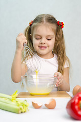 Image showing Girl playing in a cook churn whisk eggs glass bowl