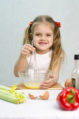 Image showing Girl playing in a cook churn whisk eggs glass bowl