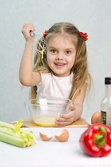 Image showing Girl playing cook churn whisk eggs in a glass bowl