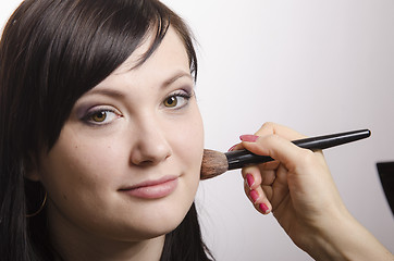 Image showing Makeup artist deals powder on the face model