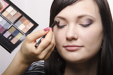 Image showing Makeup artist colors upper eyelids model