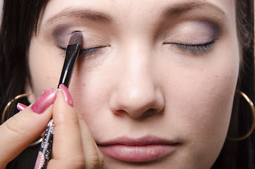 Image showing Makeup artist colors upper eyelids model