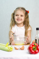 Image showing Girl playing a cook churn whisk eggs in glass bowl