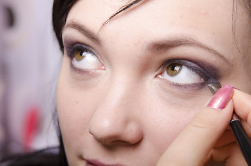 Image showing Makeup artist colors eyelashes model