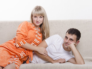 Image showing Young couple lying on sofa and looking in frame