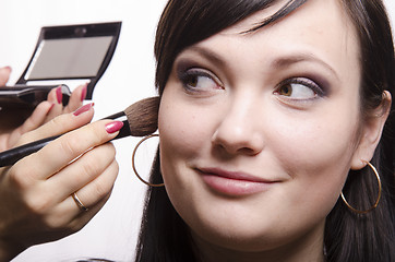 Image showing Makeup artist deals powder on the face model