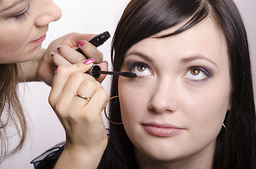 Image showing Makeup artist colors eyelashes model