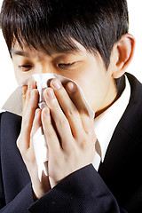 Image showing Young Man Blowing Nose into a tissue 