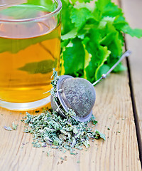 Image showing Herbal tea with mint in a mug and strainer