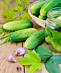 Image showing Cucumbers in jar and a wicker basket with leaves