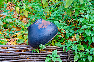 Image showing Old cast iron pot on the fence