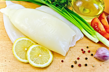 Image showing Squid with vegetables and lemon on a board