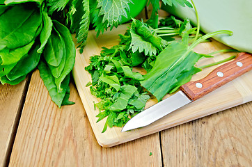 Image showing Sorrel and nettles sliced on the board with a knife