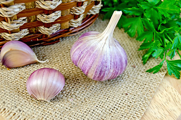 Image showing Garlic with burlap and a basket on the board