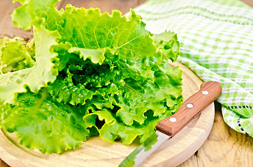 Image showing Lettuce green with knife and napkin on a board