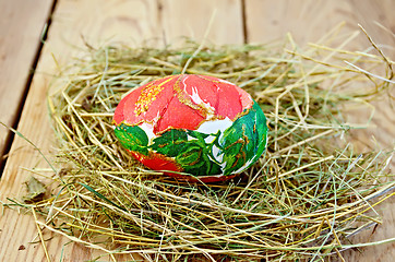 Image showing Easter egg with a red flower in the hay