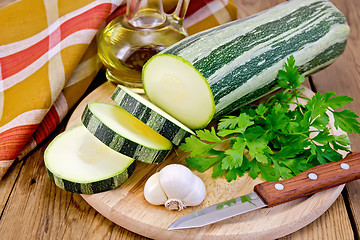 Image showing Zucchini green striped with oil on board