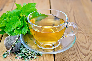 Image showing Herbal tea with melissa in a cup and strainer
