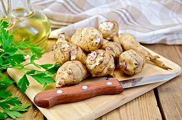 Image showing Jerusalem artichoke with a knife and oil on board