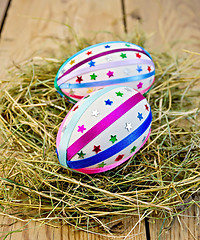 Image showing Easter eggs with ribbons and sequins in the hay