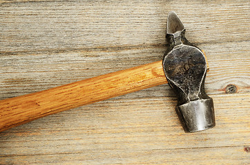 Image showing close-up of an old hammer on wooden background