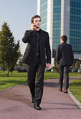 Image showing Businessman walking near office a