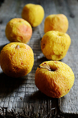 Image showing wrinkled yellow apples on a wooden