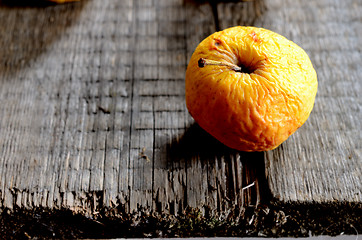 Image showing wrinkled yellow apple on a board