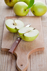 Image showing fresh green sliced apples and knife