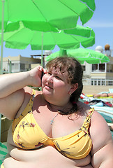 Image showing overweight woman on beach talking by phone