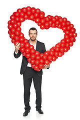 Image showing Businessman holding heart shape