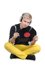Image showing Young man reading from vinyl record