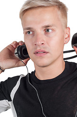 Image showing Male taking off headphones