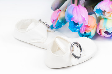 Image showing Unusual multi colored tulips and baby shoes