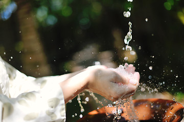 Image showing splashing fresh water on woman hands