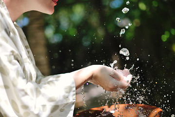 Image showing splashing fresh water on woman hands