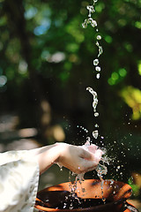 Image showing splashing fresh water on woman hands