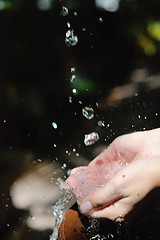 Image showing splashing fresh water on woman hands