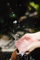 Image showing splashing fresh water on woman hands