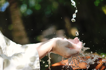 Image showing splashing fresh water on woman hands