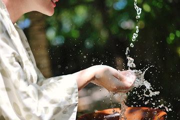 Image showing splashing fresh water on woman hands