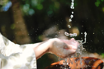 Image showing splashing fresh water on woman hands