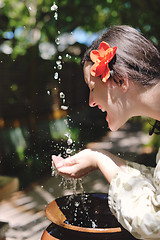 Image showing splashing fresh water on woman hands