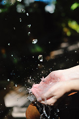 Image showing splashing fresh water on woman hands