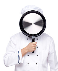 Image showing Chef with a pan in her face on white background