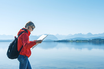 Image showing Woman tourist reading the map, traveling in Norway
