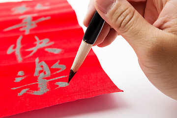 Image showing Writing of chinese new year calligraphy, phrase meaning is happy