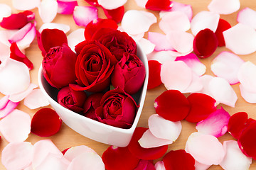 Image showing Beautiful Red rose inside heart shape bowl with petal beside